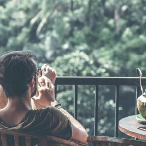 man sitting on armchair near table with opened coconut