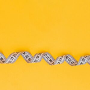 silver and black necklace on yellow textile