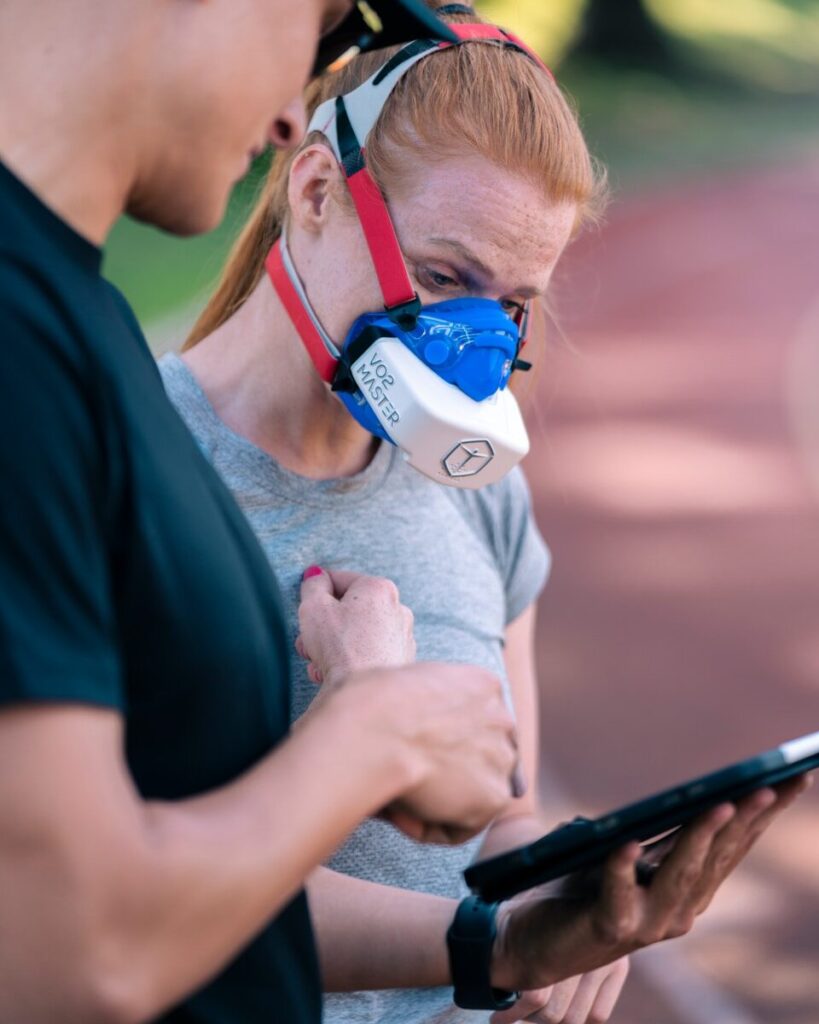 a man and a woman with a breathing mask on looking at a tablet